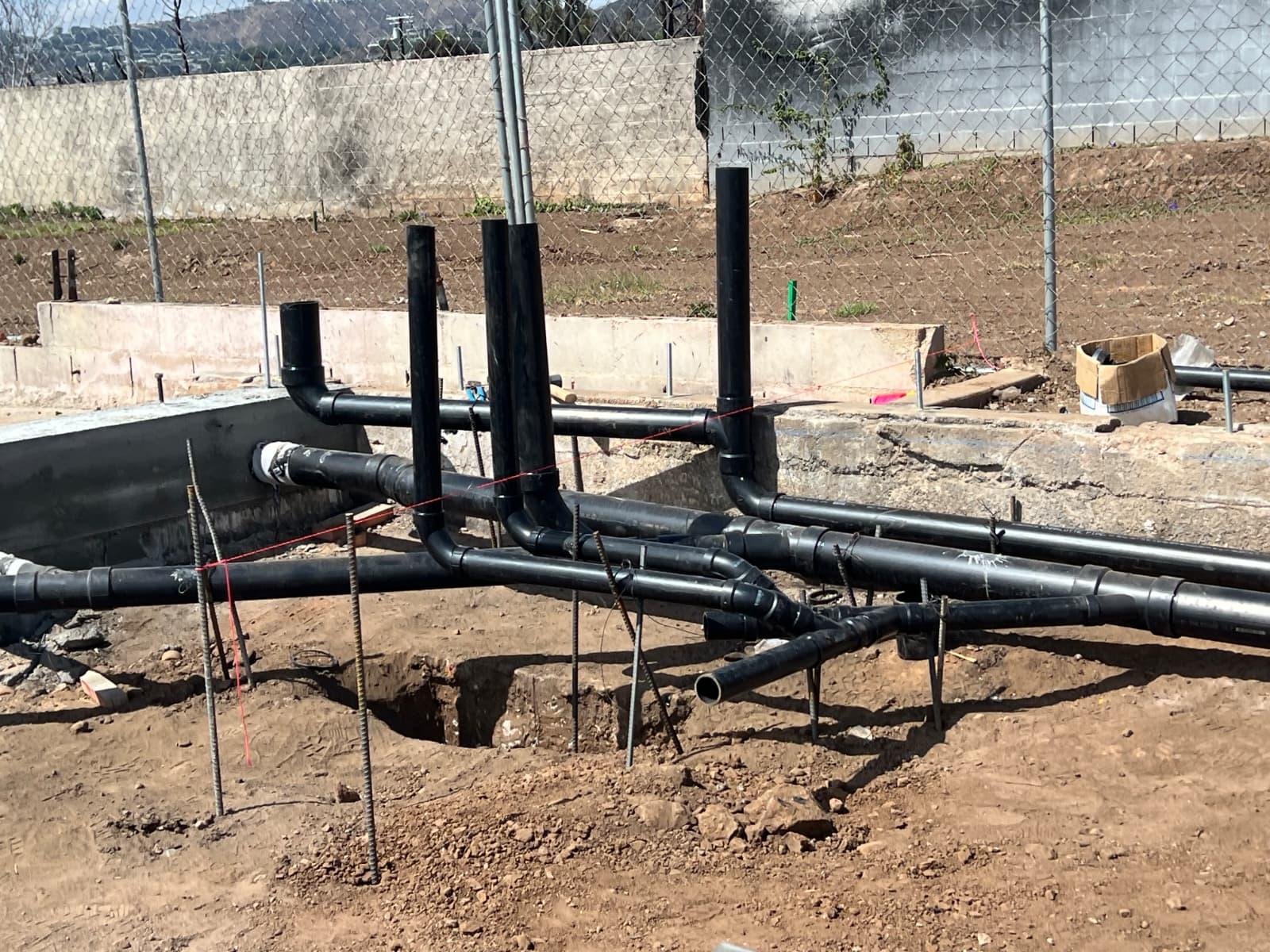 Client portfolio photograph of plumbing lines in a new-construction foundation